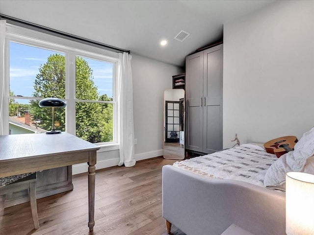 bedroom with light wood-style floors, visible vents, baseboards, and recessed lighting