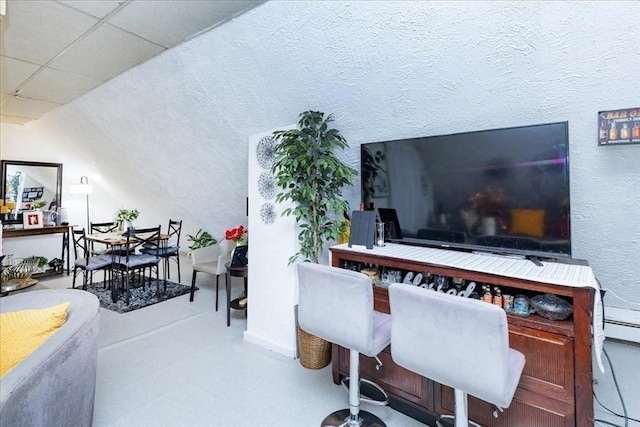 home office featuring a drop ceiling and a textured wall