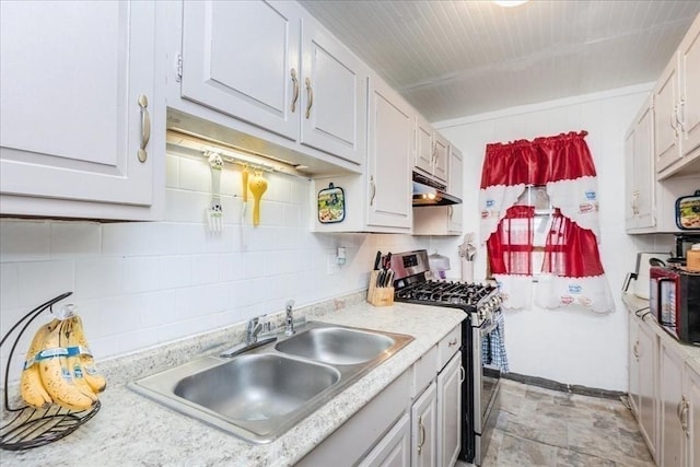 kitchen featuring black microwave, under cabinet range hood, a sink, light countertops, and stainless steel gas range