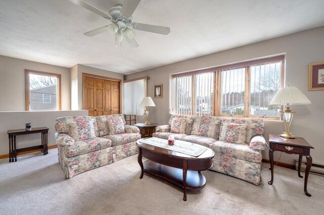 living room featuring baseboards, ceiling fan, and carpet