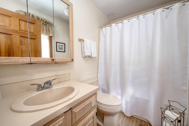 bathroom with vanity, wood finished floors, shower / bath combination with curtain, and toilet