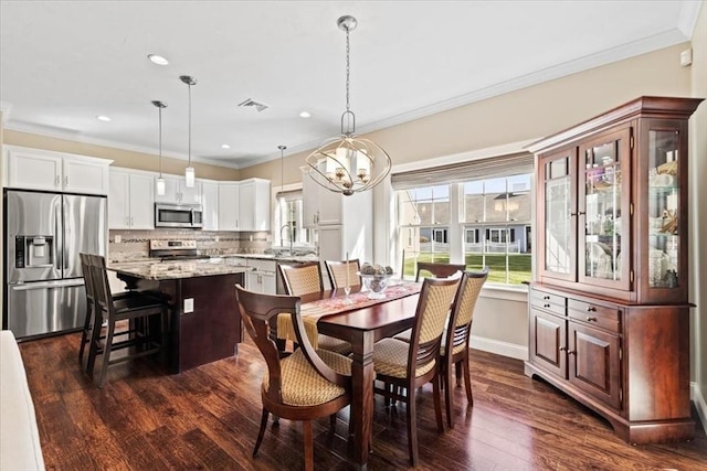 dining area featuring dark hardwood / wood-style flooring, sink, and ornamental molding