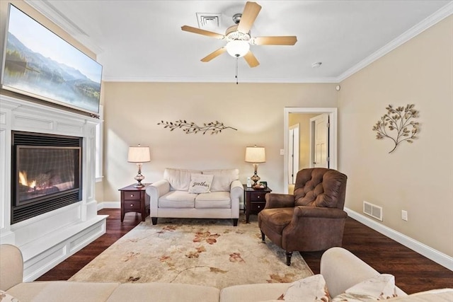 living room featuring ornamental molding, ceiling fan, and dark hardwood / wood-style flooring