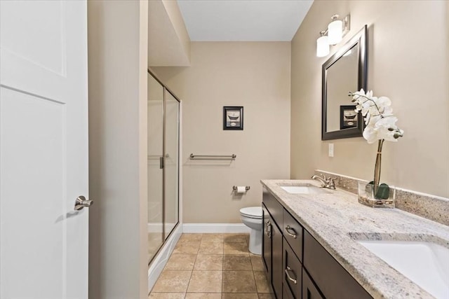 bathroom with vanity, a shower with shower door, tile patterned floors, and toilet