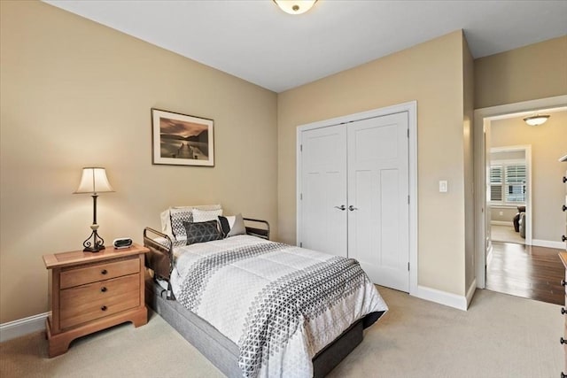 bedroom featuring light colored carpet and a closet