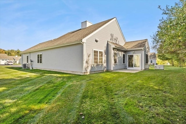 back of house featuring a lawn and a patio