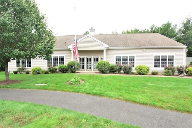 ranch-style home with french doors and a front lawn