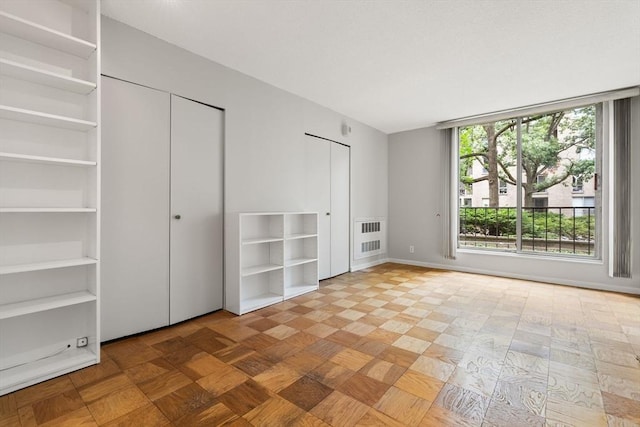 99 Pond Ave Unit 220, Brookline, MA 02445 - unfurnished bedroom featuring two closets and baseboards