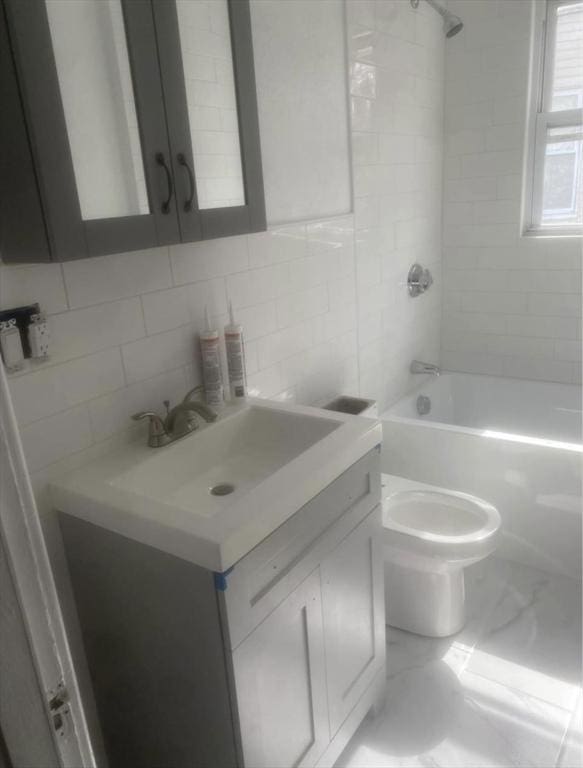 583 Center St, Fall River, MA 02720 - bathroom featuring vanity, tasteful backsplash, shower / bathtub combination, toilet, and marble look tiles