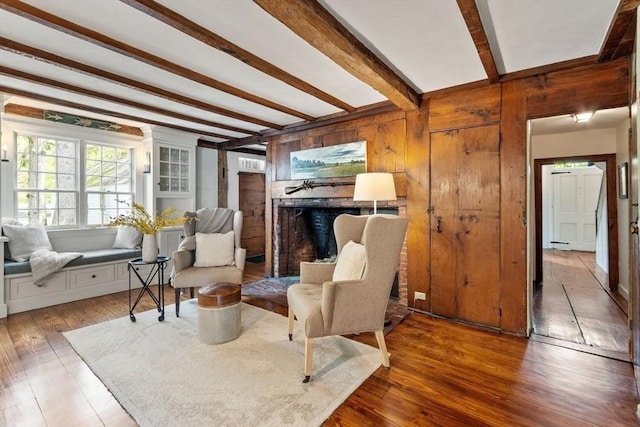 894 Great Pond Rd, North Andover, MA 01845 - living room with beam ceiling, wood finished floors, a fireplace, and wooden walls