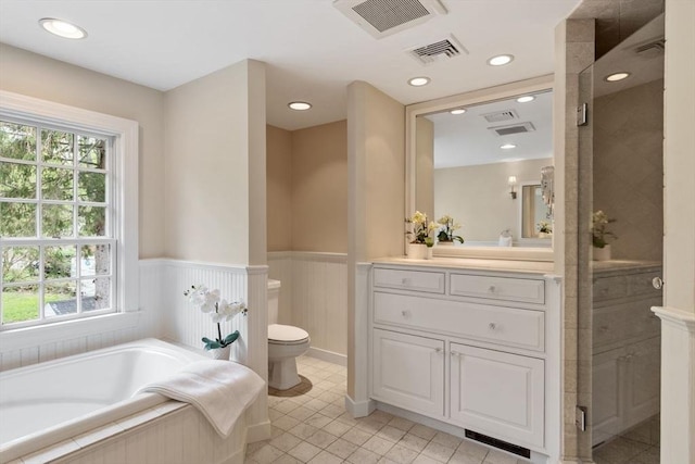 894 Great Pond Rd, North Andover, MA 01845 - full bathroom featuring toilet, plenty of natural light, vanity, a garden tub, and a wainscoted wall