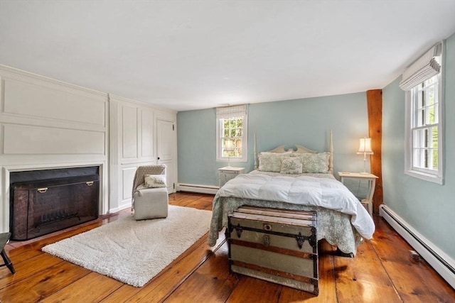 894 Great Pond Rd, North Andover, MA 01845 - bedroom featuring a baseboard heating unit, baseboard heating, hardwood / wood-style flooring, a fireplace, and baseboards