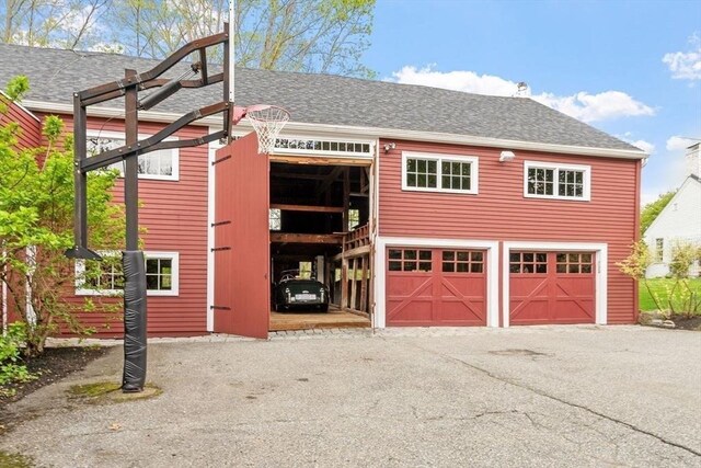 894 Great Pond Rd, North Andover, MA 01845 - view of front facade with asphalt driveway, an outbuilding, a shingled roof, and an attached garage