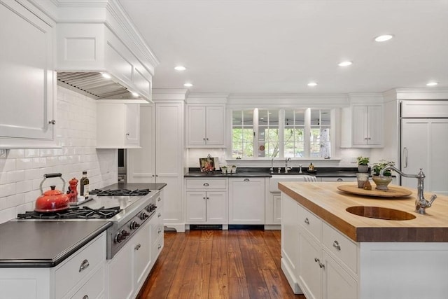 894 Great Pond Rd, North Andover, MA 01845 - kitchen with butcher block countertops, paneled refrigerator, a sink, white cabinets, and backsplash