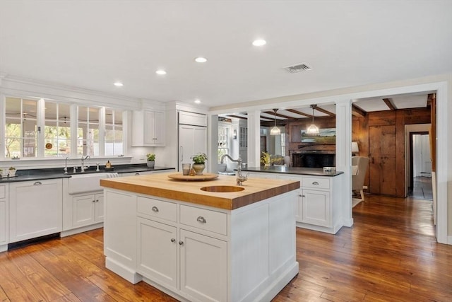 894 Great Pond Rd, North Andover, MA 01845 - kitchen with butcher block countertops, a sink, an island with sink, wood finished floors, and recessed lighting