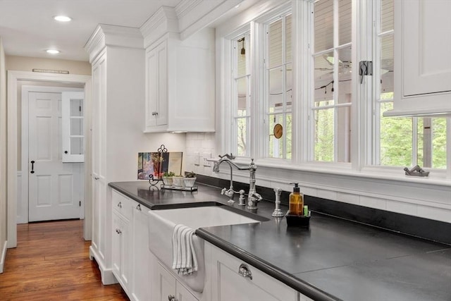 894 Great Pond Rd, North Andover, MA 01845 - kitchen with dark countertops, a sink, white cabinets, recessed lighting, and wood finished floors