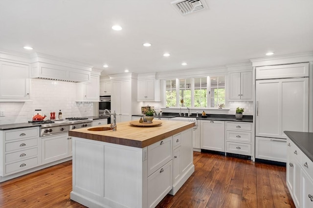 894 Great Pond Rd, North Andover, MA 01845 - kitchen with stainless steel gas cooktop, butcher block countertops, white cabinets, decorative backsplash, and recessed lighting