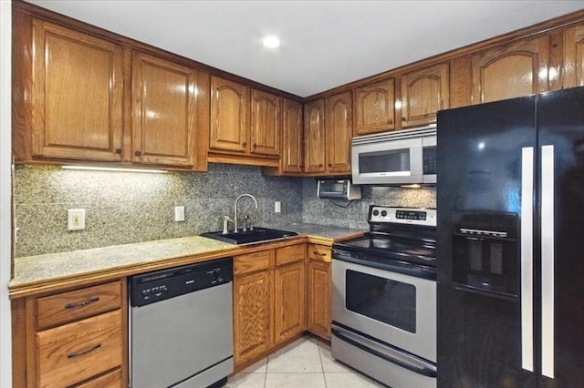 386 Great Rd Unit A3, Acton, MA 01720 - kitchen with stainless steel appliances, brown cabinets, backsplash, light tile patterned floors, and light countertops