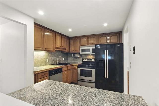 386 Great Rd Unit A3, Acton, MA 01720 - kitchen with stainless steel appliances, backsplash, recessed lighting, light countertops, and brown cabinets