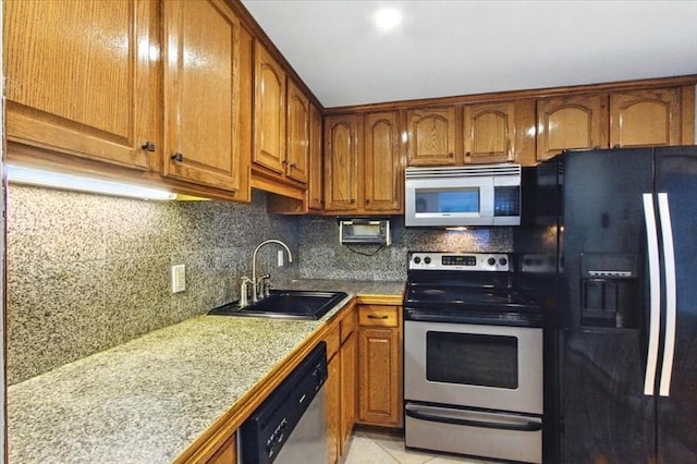 386 Great Rd Unit A3, Acton, MA 01720 - kitchen with stainless steel appliances, brown cabinetry, backsplash, and light tile patterned floors