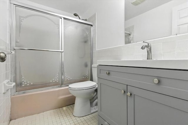 386 Great Rd Unit A3, Acton, MA 01720 - bathroom featuring tile walls, vanity, bath / shower combo with glass door, and tile patterned floors