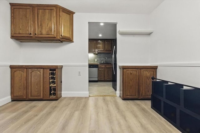386 Great Rd Unit A3, Acton, MA 01720 - bar area with dishwasher, light wood-type flooring, freestanding refrigerator, and backsplash