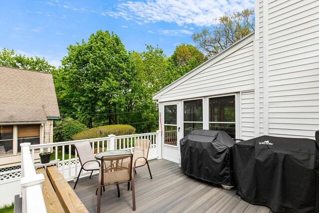 wooden deck with outdoor dining space and grilling area