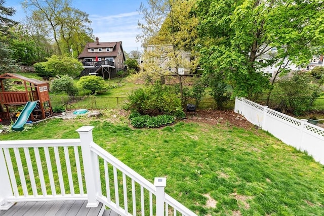 view of yard featuring a playground and a deck