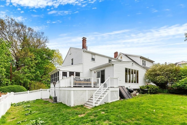 rear view of house with a chimney, a sunroom, a deck, and stairway