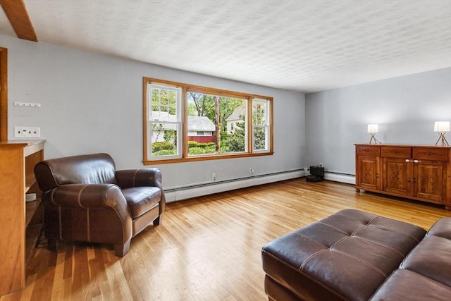 living area with a baseboard heating unit and light wood-type flooring