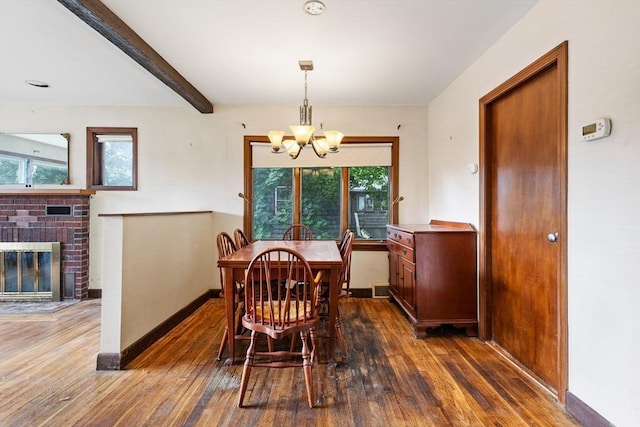 dining room with beamed ceiling, dark hardwood / wood-style floors, a wealth of natural light, and a fireplace