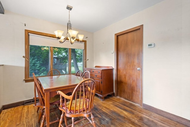 dining space featuring a notable chandelier and dark hardwood / wood-style flooring