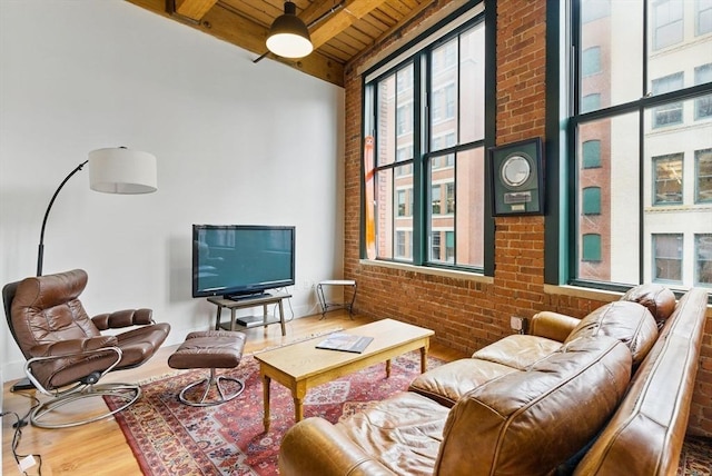 49 Melcher St Unit 405, Boston, MA 02110 - living area featuring wooden ceiling with exposed beams, brick wall, and wood finished floors