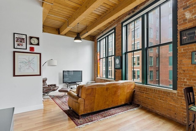 49 Melcher St Unit 405, Boston, MA 02110 - living room with wood ceiling with exposed beams, wood finished floors, brick wall, and baseboards