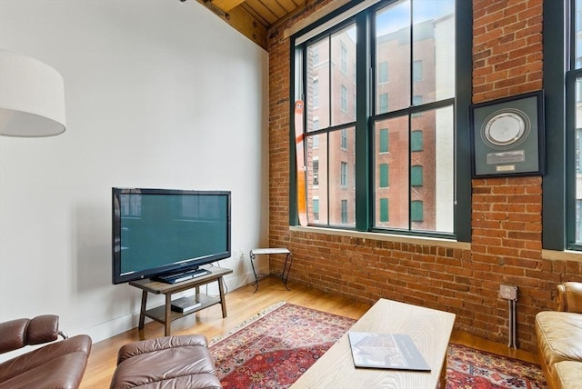 49 Melcher St Unit 405, Boston, MA 02110 - living area with brick wall, plenty of natural light, wood finished floors, and wooden ceiling