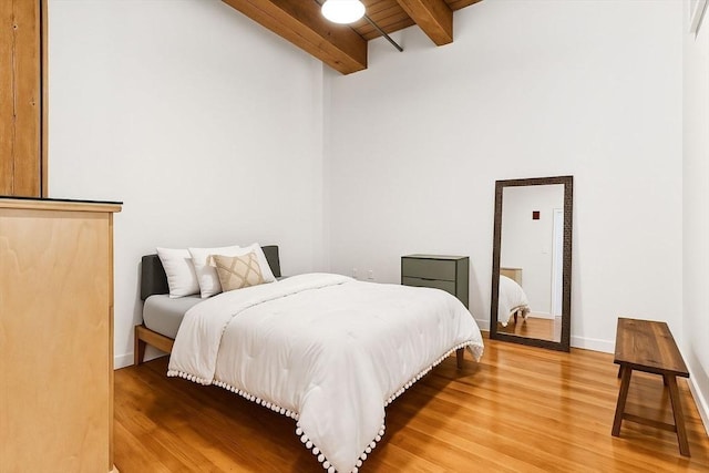 49 Melcher St Unit 405, Boston, MA 02110 - bedroom featuring light wood-style floors, beam ceiling, a high ceiling, and baseboards