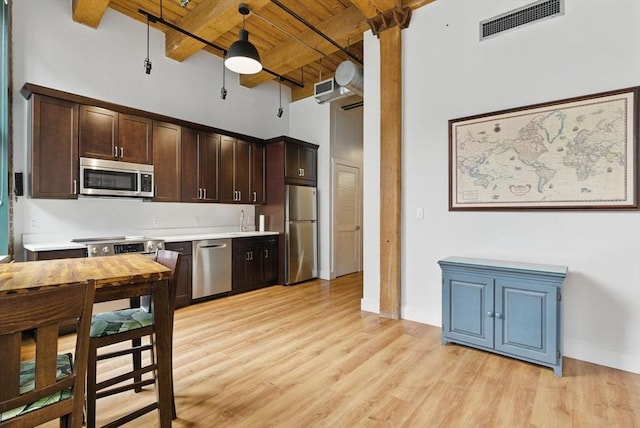 49 Melcher St Unit 405, Boston, MA 02110 - kitchen featuring appliances with stainless steel finishes, wooden ceiling with exposed beams, dark brown cabinetry, a ceiling fan, and light countertops