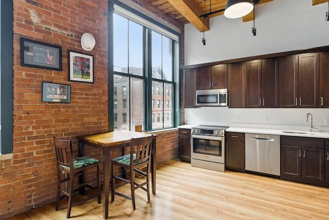 49 Melcher St Unit 405, Boston, MA 02110 - kitchen with stainless steel appliances, a sink, plenty of natural light, wood ceiling with exposed beams, and light wood-style flooring