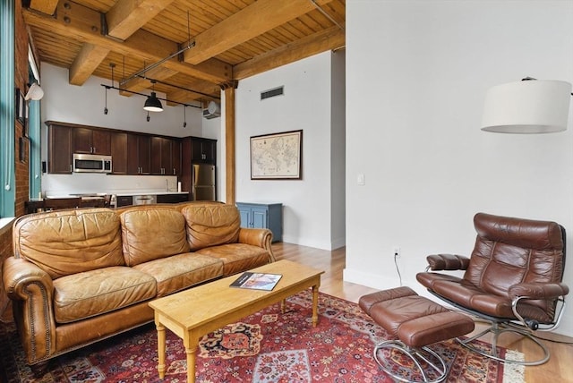 49 Melcher St Unit 405, Boston, MA 02110 - living room featuring wooden ceiling with exposed beams, light wood finished floors, a high ceiling, and baseboards