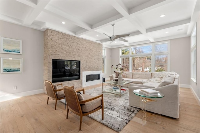 living area with light wood-type flooring, coffered ceiling, a fireplace, and baseboards