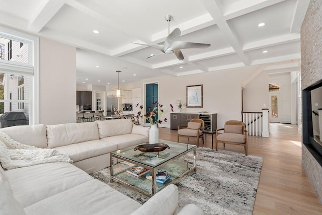 living room featuring recessed lighting, coffered ceiling, beam ceiling, and light wood-style floors