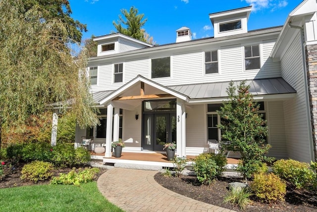 back of property featuring a standing seam roof, metal roof, and a porch