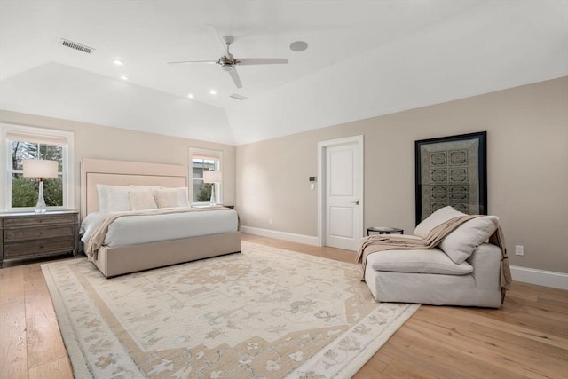 bedroom with visible vents, vaulted ceiling, light wood finished floors, and multiple windows