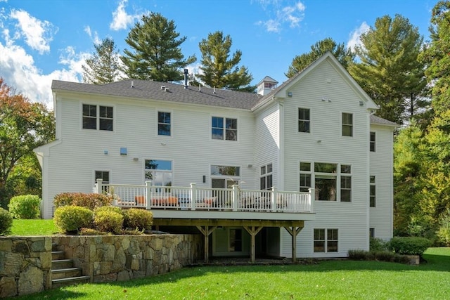 rear view of house with a lawn and a wooden deck