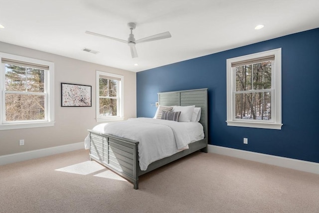 bedroom with visible vents, ceiling fan, light colored carpet, and baseboards