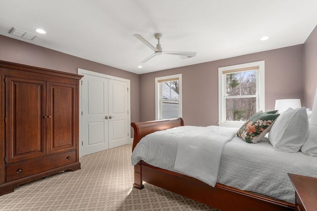 bedroom featuring recessed lighting, visible vents, light carpet, and multiple windows