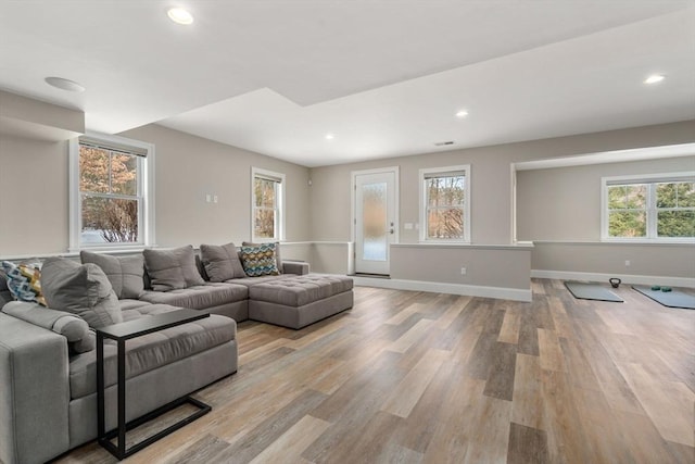 living room featuring light wood-style floors, recessed lighting, visible vents, and baseboards