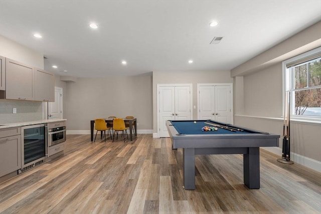 playroom with beverage cooler, light wood-type flooring, baseboards, and recessed lighting