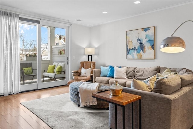 living room featuring ornamental molding and light hardwood / wood-style flooring