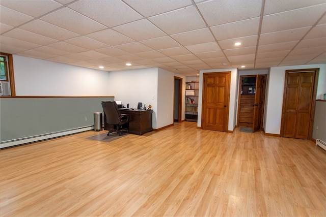 office featuring a baseboard radiator, light wood-type flooring, and a paneled ceiling